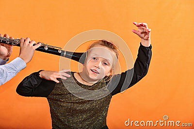 The boy plays the clarinet in the girlâ€™s ear, the outraged girl waves her arms Stock Photo